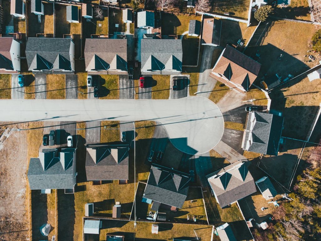 pexels photo 6319128 Drone view of residential district with modern houses and yard on sunny day in summer